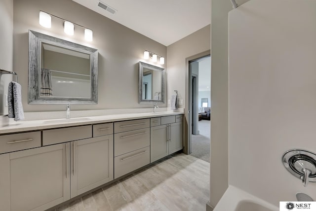 full bathroom with visible vents, a sink, and double vanity