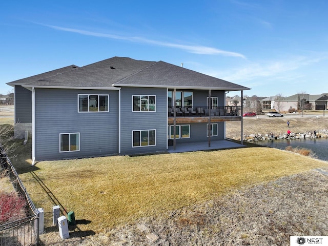 back of property featuring a yard, a shingled roof, and a patio area