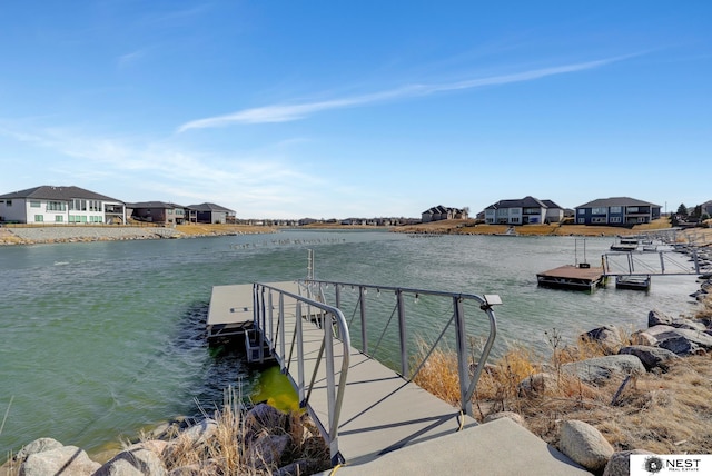 view of dock with a water view and a residential view