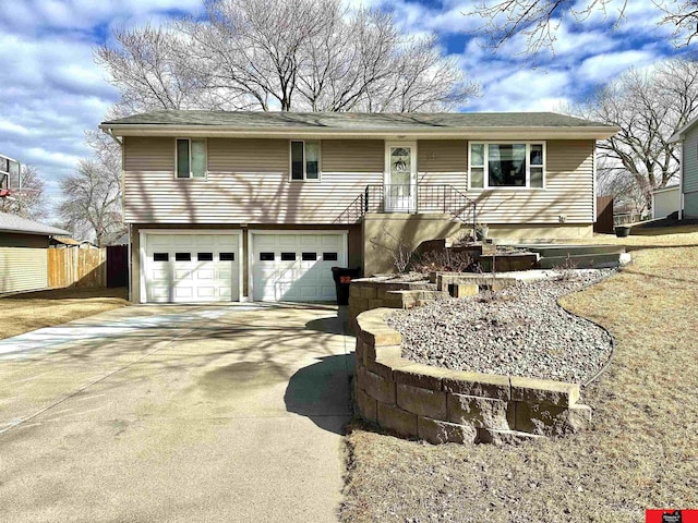 view of front of house with an attached garage, fence, and concrete driveway