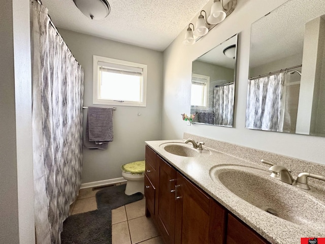 full bathroom with tile patterned flooring, a sink, a textured ceiling, and toilet