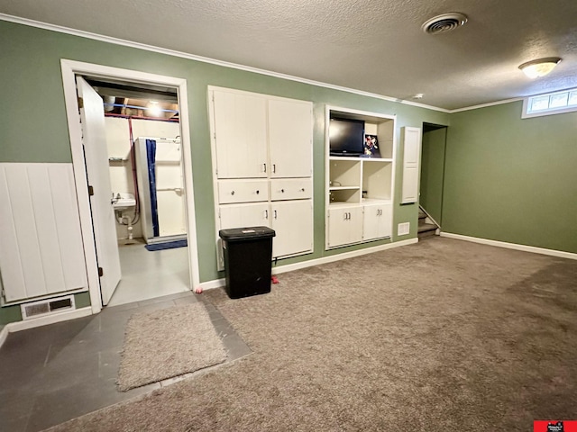 unfurnished bedroom featuring visible vents, carpet flooring, a textured ceiling, and ornamental molding