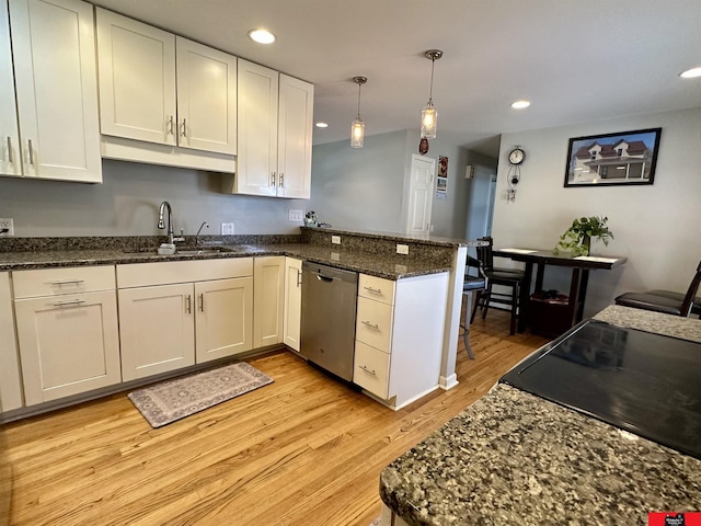 kitchen featuring recessed lighting, light wood-style flooring, a sink, dishwasher, and a peninsula