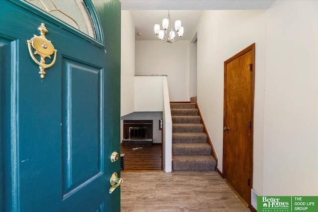 entrance foyer with a notable chandelier, stairs, baseboards, and wood finished floors