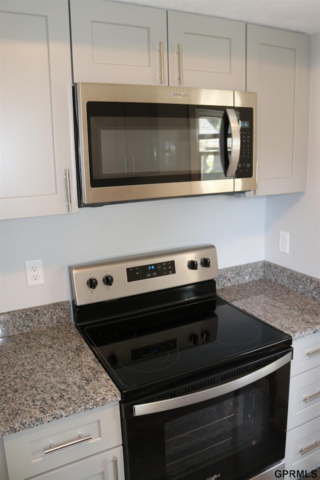 kitchen featuring white cabinets, light stone countertops, and stainless steel appliances