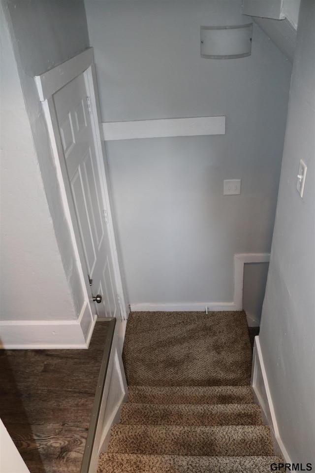 stairway featuring carpet flooring and baseboards