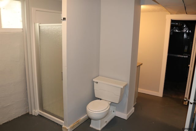 full bathroom featuring concrete floors, a shower stall, toilet, and baseboards