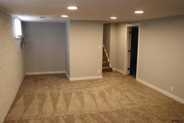 basement featuring carpet floors, recessed lighting, baseboards, and stairs