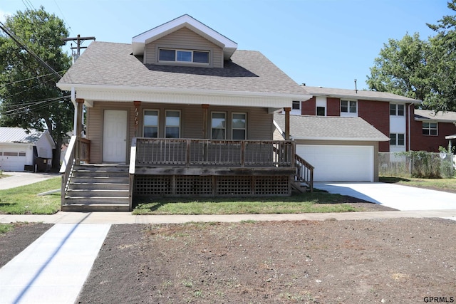 bungalow-style home featuring a garage, driveway, a shingled roof, covered porch, and an outdoor structure