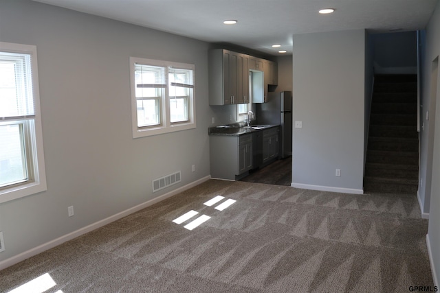 kitchen with carpet floors, visible vents, freestanding refrigerator, dishwasher, and baseboards