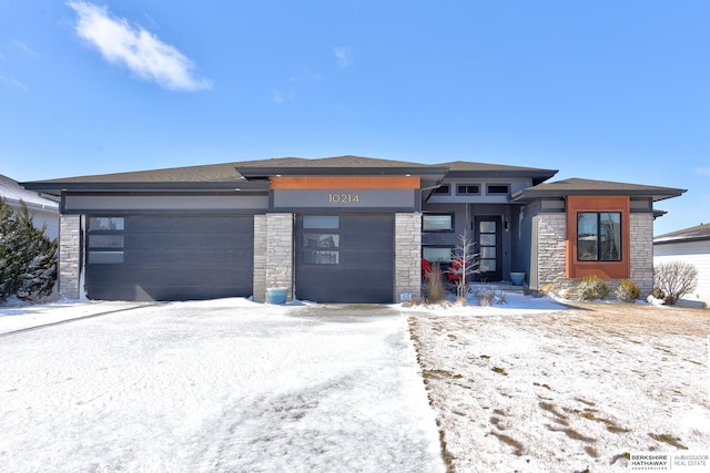 prairie-style house featuring a garage and stone siding