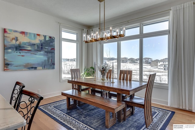 dining area featuring plenty of natural light, light wood-style flooring, and baseboards