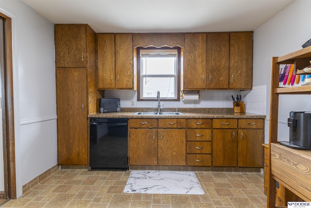 kitchen featuring black dishwasher, brown cabinetry, and a sink