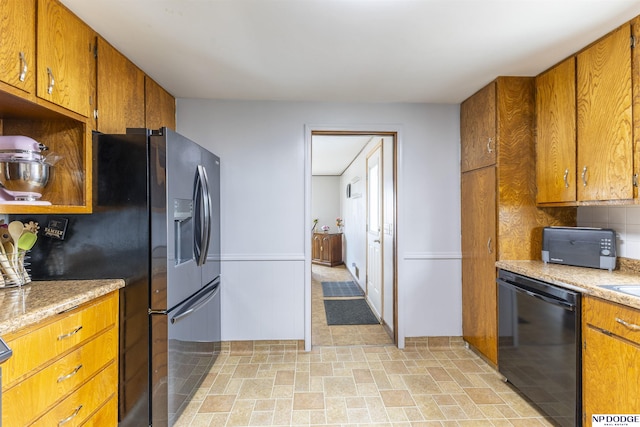 kitchen with brown cabinets, light countertops, backsplash, fridge with ice dispenser, and dishwasher