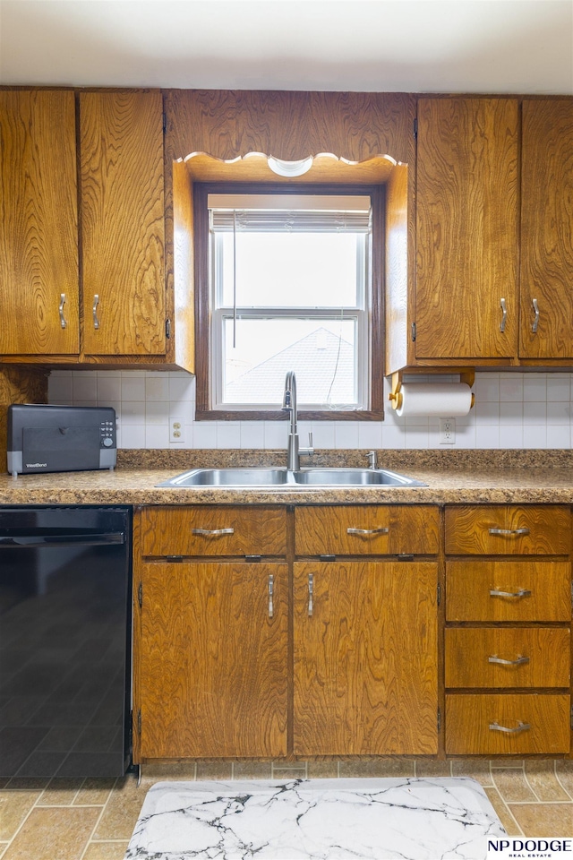 kitchen featuring a sink, brown cabinetry, and dishwasher