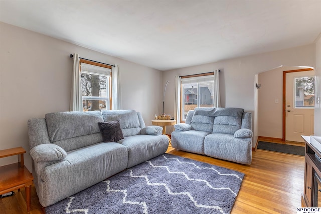 living room with arched walkways and wood finished floors