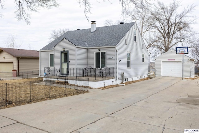 view of front of property with roof with shingles, a chimney, concrete driveway, fence, and an outdoor structure