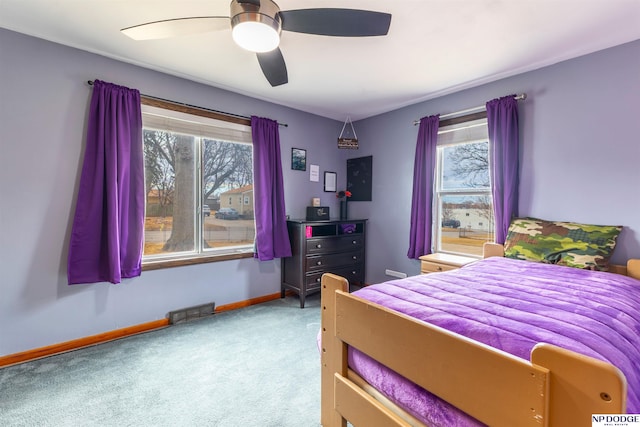 bedroom with carpet floors, baseboards, multiple windows, and visible vents