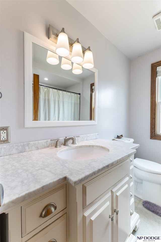 bathroom featuring toilet, visible vents, and vanity