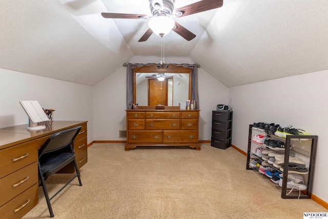 office featuring lofted ceiling, a textured ceiling, baseboards, and light colored carpet