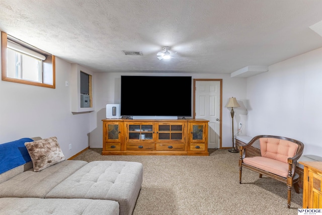 carpeted living area featuring a textured ceiling, visible vents, and baseboards