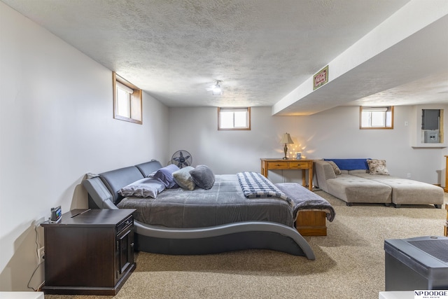 carpeted bedroom featuring multiple windows and a textured ceiling