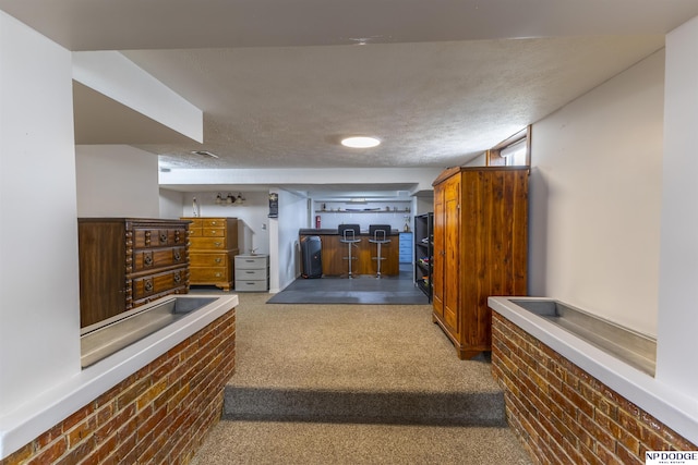 hall featuring a textured ceiling and carpet