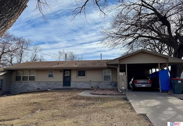 ranch-style house with stone siding, a carport, and concrete driveway