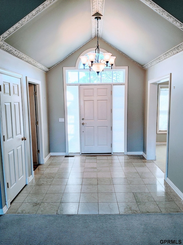 foyer entrance featuring lofted ceiling, baseboards, and an inviting chandelier