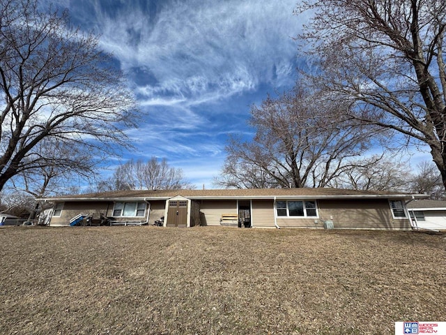 view of front facade with brick siding and a front lawn