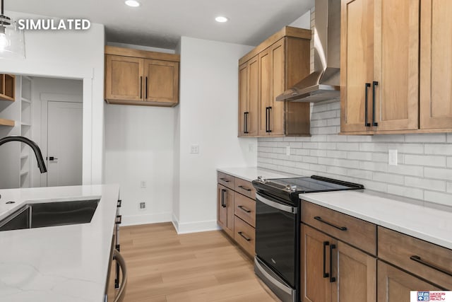 kitchen with brown cabinets, light wood-style flooring, a sink, wall chimney range hood, and range with electric cooktop