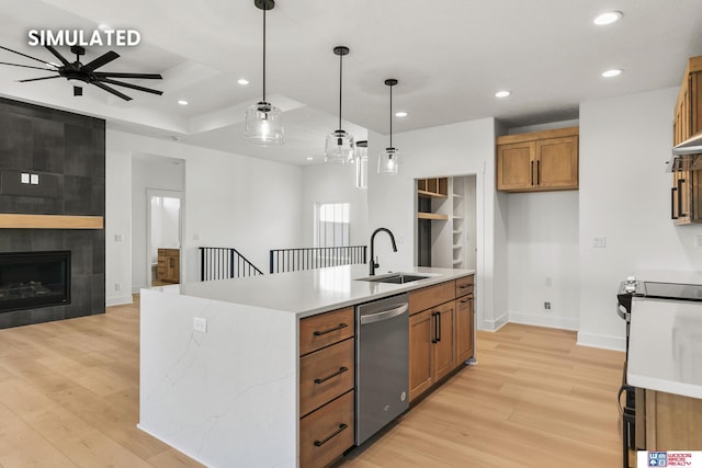 kitchen featuring stove, a sink, stainless steel dishwasher, light wood finished floors, and brown cabinetry