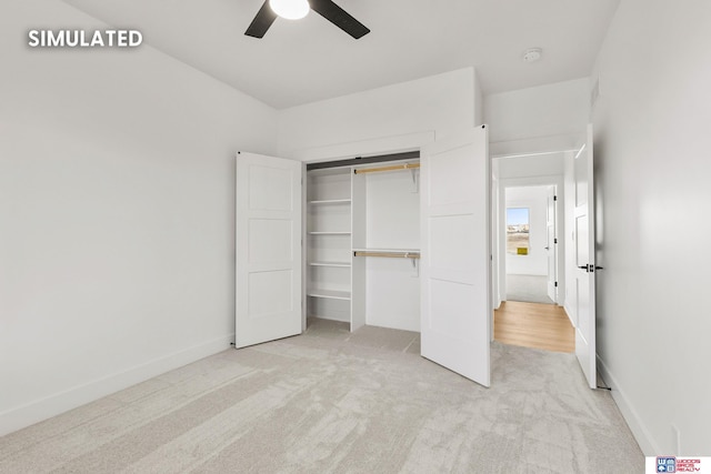 unfurnished bedroom featuring a closet, light colored carpet, ceiling fan, and baseboards