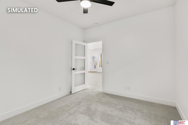 carpeted empty room with ceiling fan and baseboards