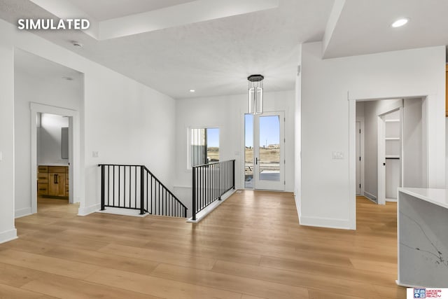 hall featuring light wood-type flooring, baseboards, an upstairs landing, and recessed lighting