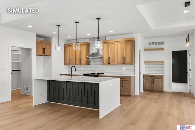 kitchen with brown cabinets, light countertops, visible vents, a sink, and light wood-type flooring