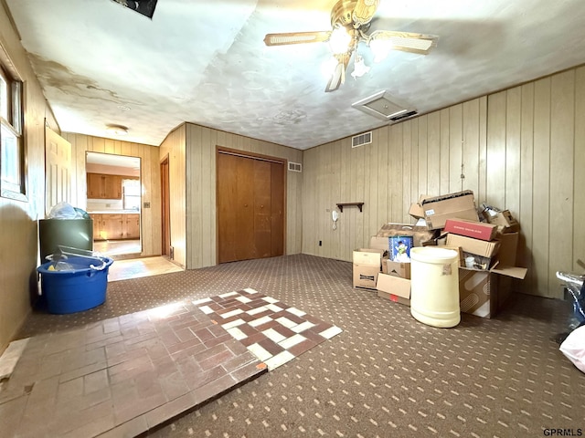 interior space featuring attic access, wooden walls, and visible vents