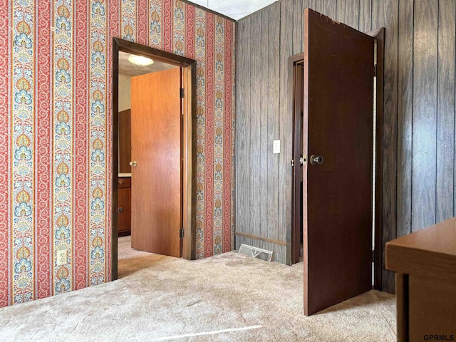 hall featuring wallpapered walls and carpet flooring