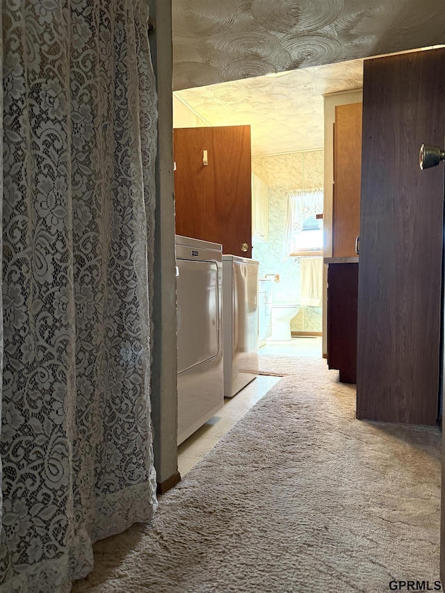 washroom featuring washer / dryer, laundry area, and light carpet