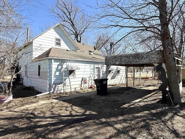 rear view of property featuring roof with shingles