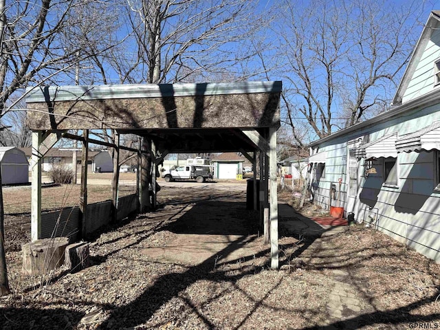 view of yard featuring a storage shed, a carport, and an outbuilding