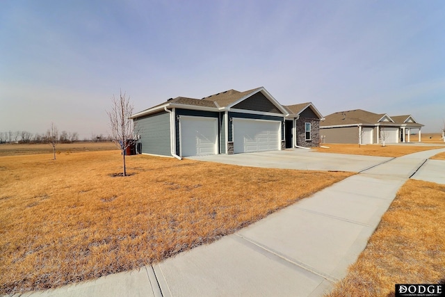 ranch-style house featuring an attached garage, driveway, and a front lawn