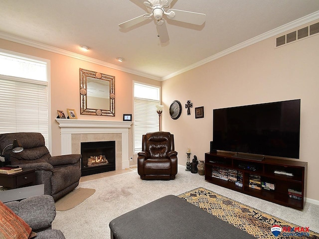 living room with carpet, crown molding, a fireplace, visible vents, and a ceiling fan