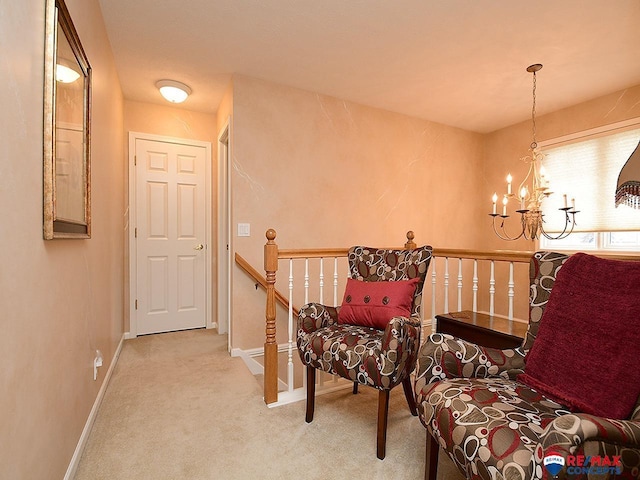 living area with a notable chandelier, carpet flooring, an upstairs landing, and baseboards