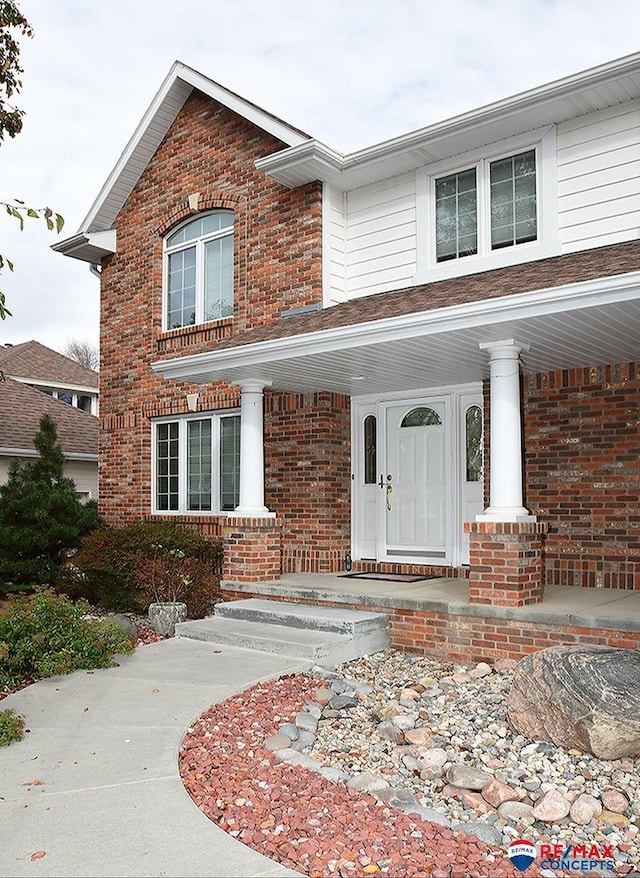 view of front of house featuring covered porch and brick siding