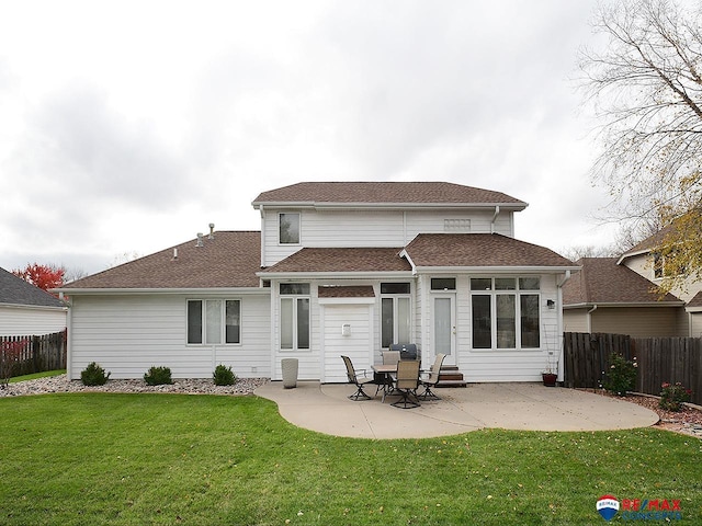 rear view of property featuring a lawn, a patio area, and fence