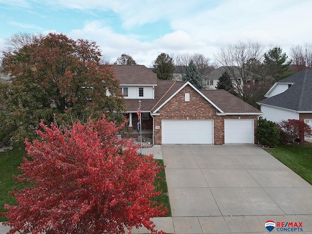 traditional home featuring concrete driveway, brick siding, and an attached garage