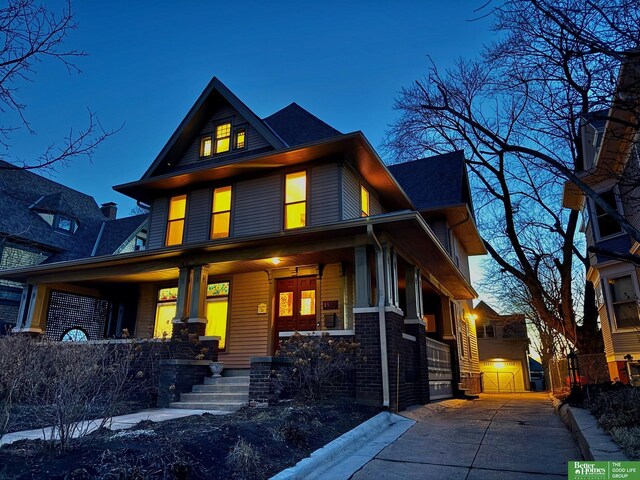 american foursquare style home with covered porch and brick siding