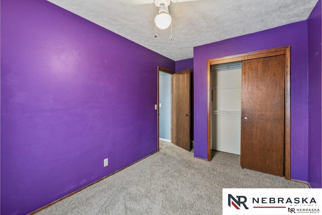 unfurnished bedroom with carpet floors, a closet, a ceiling fan, and a textured ceiling