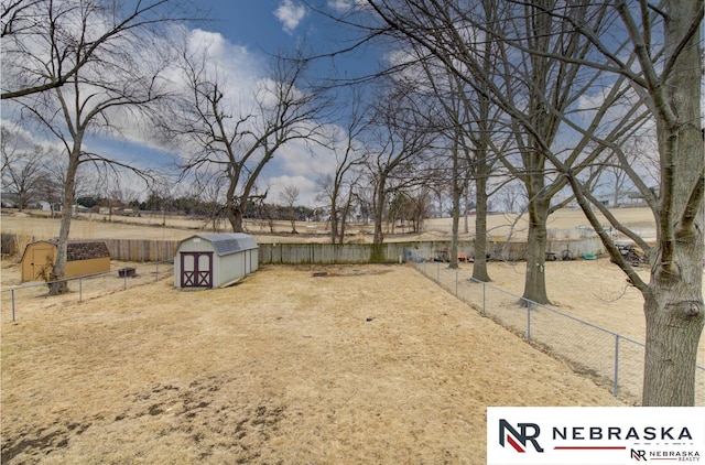 view of yard featuring a shed, an outdoor structure, and a fenced backyard